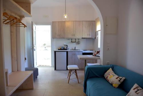sala de estar con sofá azul y cocina en Flora's Houses Mykonos, en Klouvas