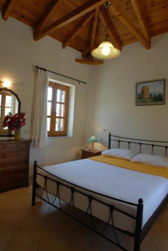 a bedroom with a large bed and a wooden ceiling at Mouses Apartments-Kardamyli in Kardamyli