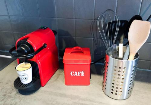 a red toaster and a container with utensils on a counter at L'hôte en pierre in Blois