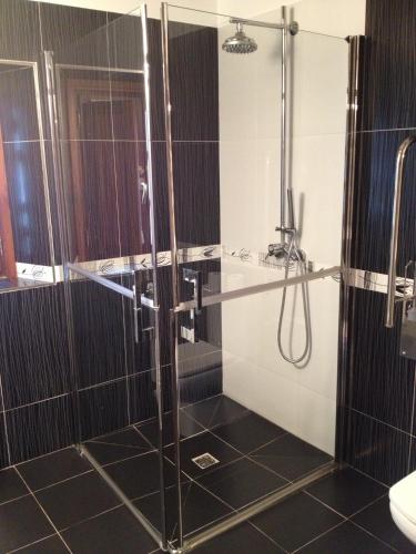 a bathroom with a glass shower with a sink at Casa Rural Garabilla in Santa Coloma