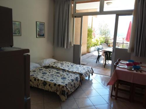 a bedroom with a bed and a balcony with a table at Residence Cascata Varone in Riva del Garda