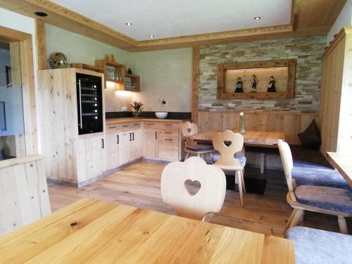 a kitchen with wooden floors and a table and chairs at Tirol Appartement Haus Zillertal in Zell am Ziller