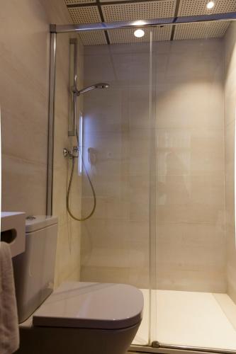 a bathroom with a glass shower with a toilet at Hostal Paris in Barcelona