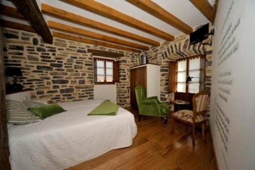 Pokój z łóżkiem i kamienną ścianą w obiekcie Casa Rural Garabilla w mieście Santa Coloma