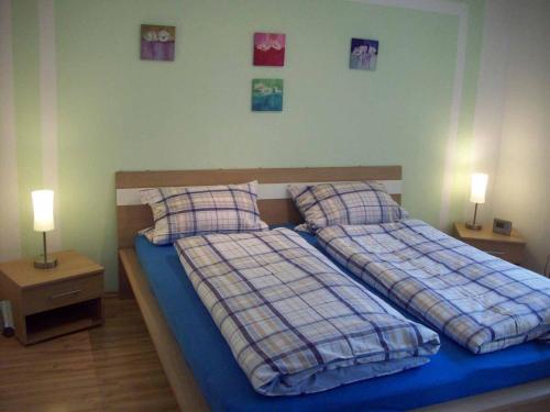 two beds in a bedroom with two lamps on tables at Ferienwohnung Brunner in Grafenau