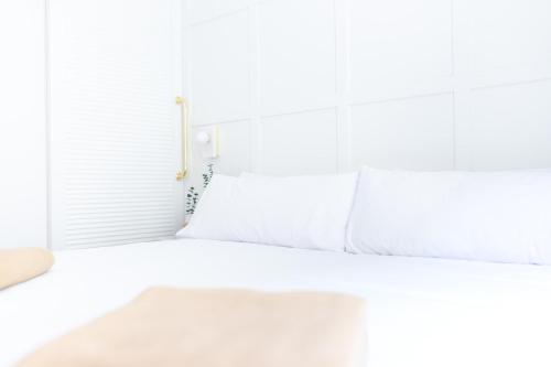 a white bed with white pillows and a window at Room Mate Cosmo - City Centre, Valencia in Valencia