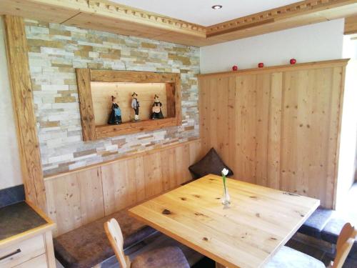 a wooden table in a room with a stone wall at Tirol Appartement Haus Zillertal in Zell am Ziller
