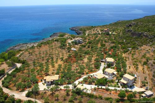 an aerial view of a house on a hill next to the ocean at Mouses Apartments-Kardamyli in Kardamili