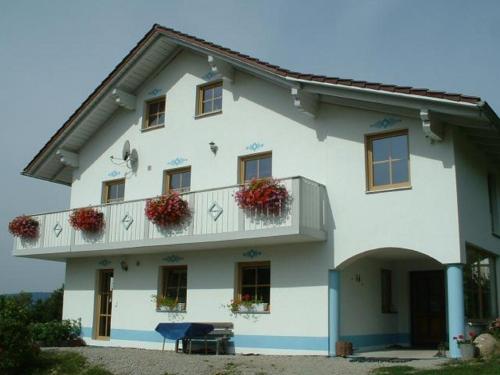 a white building with flower boxes on the balcony at Ferienwohnung Brunner in Grafenau