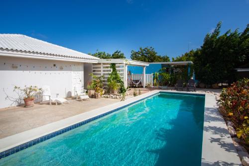 una piscina frente a una casa en Tropical Breeze "Dushi Bida", en Santa Catharina