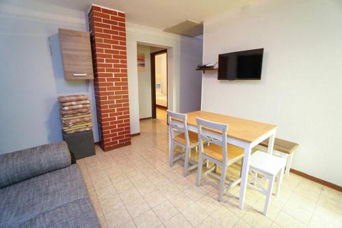a dining room with a table and chairs and a television at Apartment Marko in Crveni Vrh
