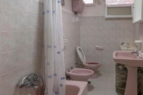 a bathroom with a pink toilet and a sink at Il Mare In Giardino in Scauri