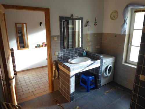 a bathroom with a sink and a washing machine at Ferienwohnung Ostseewald in Rostock