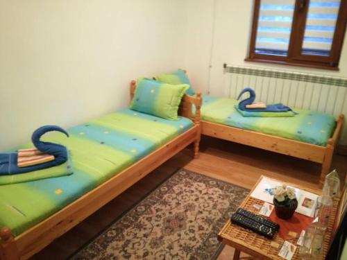 two twin beds in a room with a table at Villa Bulgarka in Divchovoto