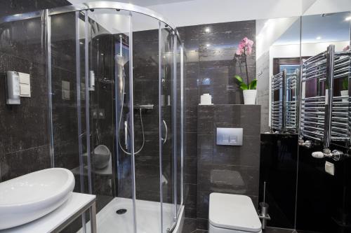 a bathroom with a shower and a toilet and a sink at Hotel Unicus Krakow Old Town in Kraków