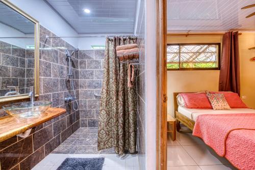 a bathroom with a bed and a shower at Cabinas Yucca in Puerto Viejo