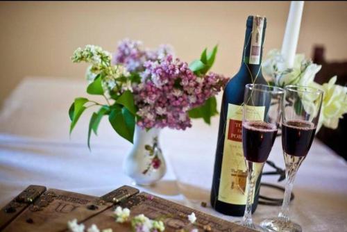 a table with two glasses of wine and flowers at Hotel Restauracja U Guta in Klikuszowa