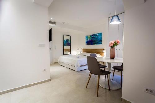 Un dormitorio con una cama y una mesa con un jarrón de flores en Villa Katarina en Makarska
