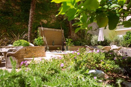 a garden with a table and chairs and flowers at Best Western Premier Le Patio des Artistes Wellness Jacuzzi in Cannes