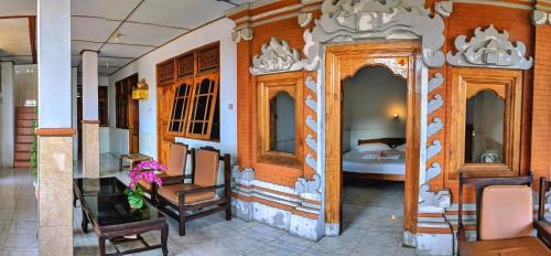 een kamer met een bed en een tafel en stoelen bij Serangan Inn II in Padangbai