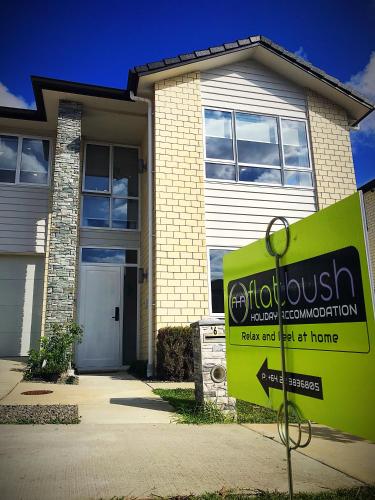 a house with a sign in front of it at Flat Bush Holiday Accomodation in Auckland