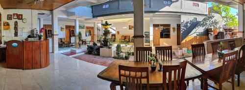 a restaurant with a table and chairs in a room at Serangan Inn II in Padangbai