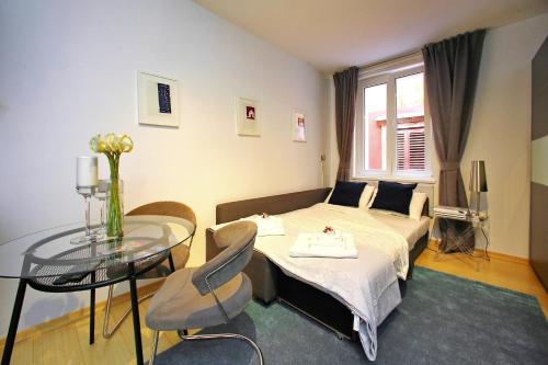 a hotel room with a bed and a glass table at Globe Apartament 2 in Zadar