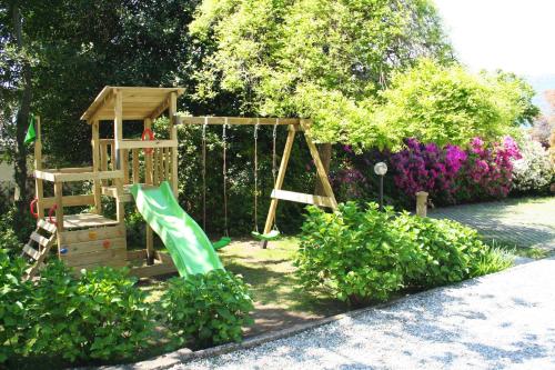 a playground in a garden with a swing at Villa dei Fiori in Luino