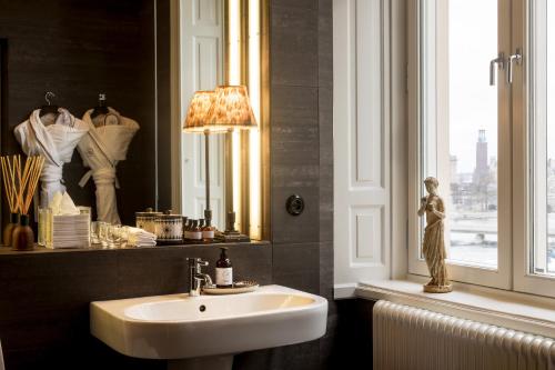 a bathroom with a sink and a mirror and a window at Lydmar Hotel in Stockholm