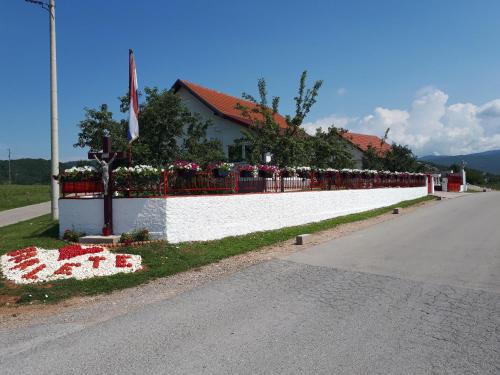 a fence with flowers on the side of a road at Vila NINA in Gospić