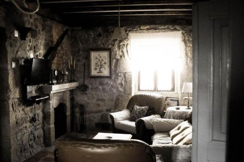 a living room with a couch and a fireplace at The Bakery Guesthouse in Fundão