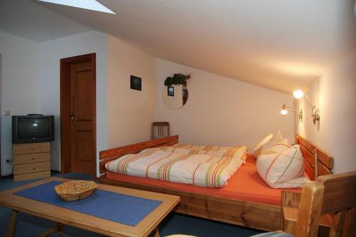 - une chambre avec un lit et une télévision dans l'établissement Lärcheck, à Ramsau bei Berchtesgaden