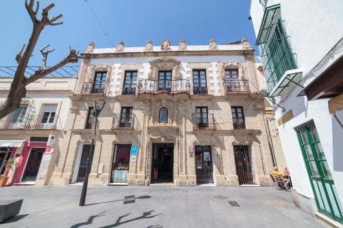 an old building in the middle of a street at Casa Palacio de los Leones in El Puerto de Santa María