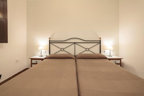 a bedroom with a large bed with two night stands at Casa Palacio de los Leones in El Puerto de Santa María