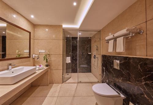 a bathroom with a sink toilet and a shower at Shivas Galaxy Hotel in Devanhalli