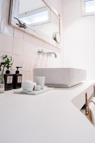 a white bathroom with a sink and a mirror at São Paulo Boutique Hotel - SPBH in Tavira