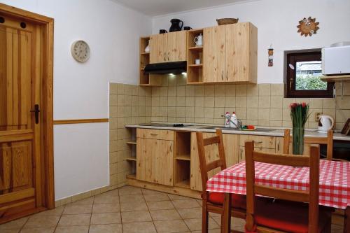 una cocina con armarios de madera, mesa y sillas en Ubytování U Rohelů, en Karlova Studánka