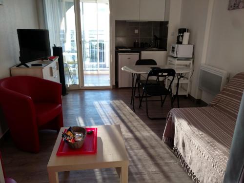 Il comprend un salon avec un lit, une table et une cuisine. dans l'établissement Jolis Studios vue sur mer Port, Etangs et Canaux Résidence RIVERCITY, à Carnon-Plage