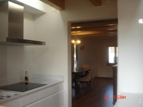 cocina y comedor con mesa de fondo en Ca l' Ermitanyo- Casa Torre Blanca, en Súria