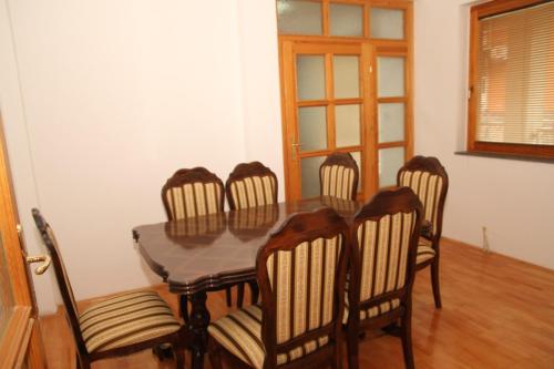 Apartman Goražde في Goražde: غرفة طعام مع طاولة وستة كراسي