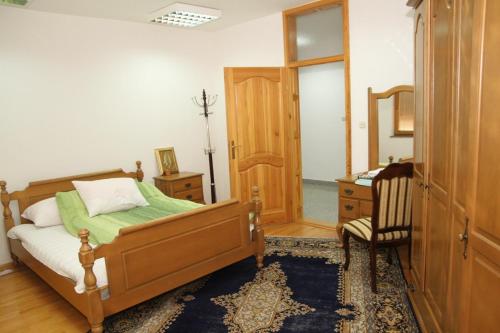 Apartman Goražde في Goražde: غرفة نوم بسرير وكرسي ومرآة
