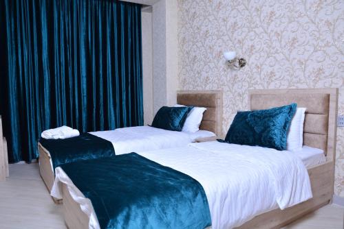 Duas camas sentadas uma ao lado da outra num quarto em Global Hotel Baku em Baku