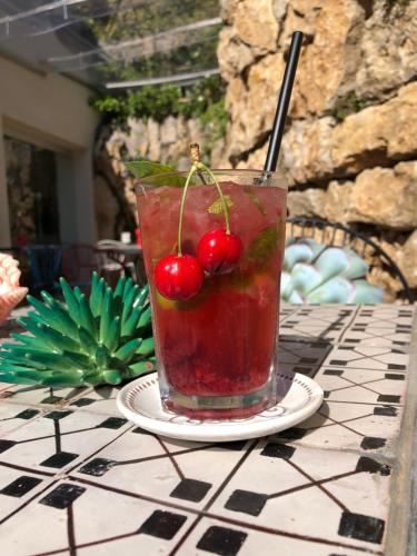 una bebida con cerezas en ella sentada en una mesa en Hotel Orsa Maggiore en Anacapri