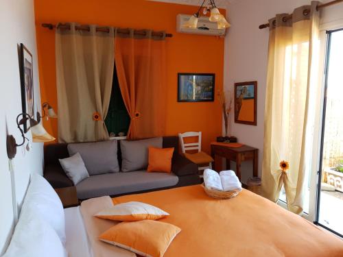 a living room with a bed and a couch at Violetta Rooms in Koroni