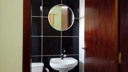 a bathroom with a sink and a mirror on a wall at Pousada Tiriri Guesthouse in Barra do Camaragibe