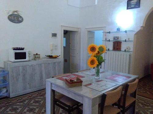 una cocina con una mesa con un jarrón de girasoles. en House 1909, en Ostuni