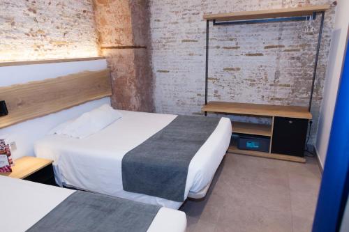 um quarto de hotel com duas camas e uma janela em Hostal Paris em Barcelona