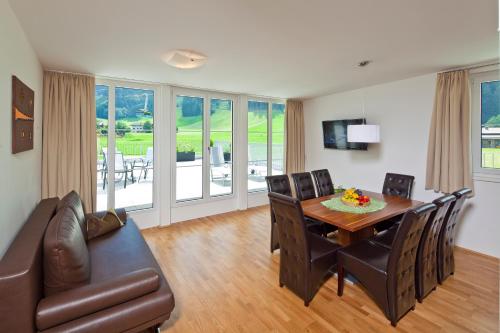 a living room with a dining room table and a couch at Apart Mountain Lodge Mayrhofen in Mayrhofen