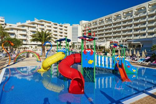 a swimming pool with a water slide in a resort at Hipotels Coma Gran in Sa Coma