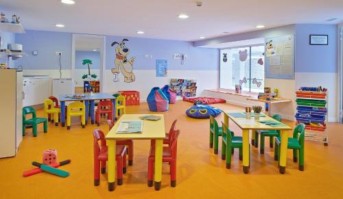 a classroom with tables and chairs in a room at Hipotels Coma Gran in Sa Coma